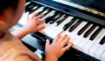 ピアノを弾く子どもの後ろ姿のイメージ